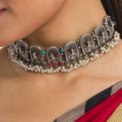 "Oxidized peacock choker with white pearls and colorful stones radiates vintage charm."
