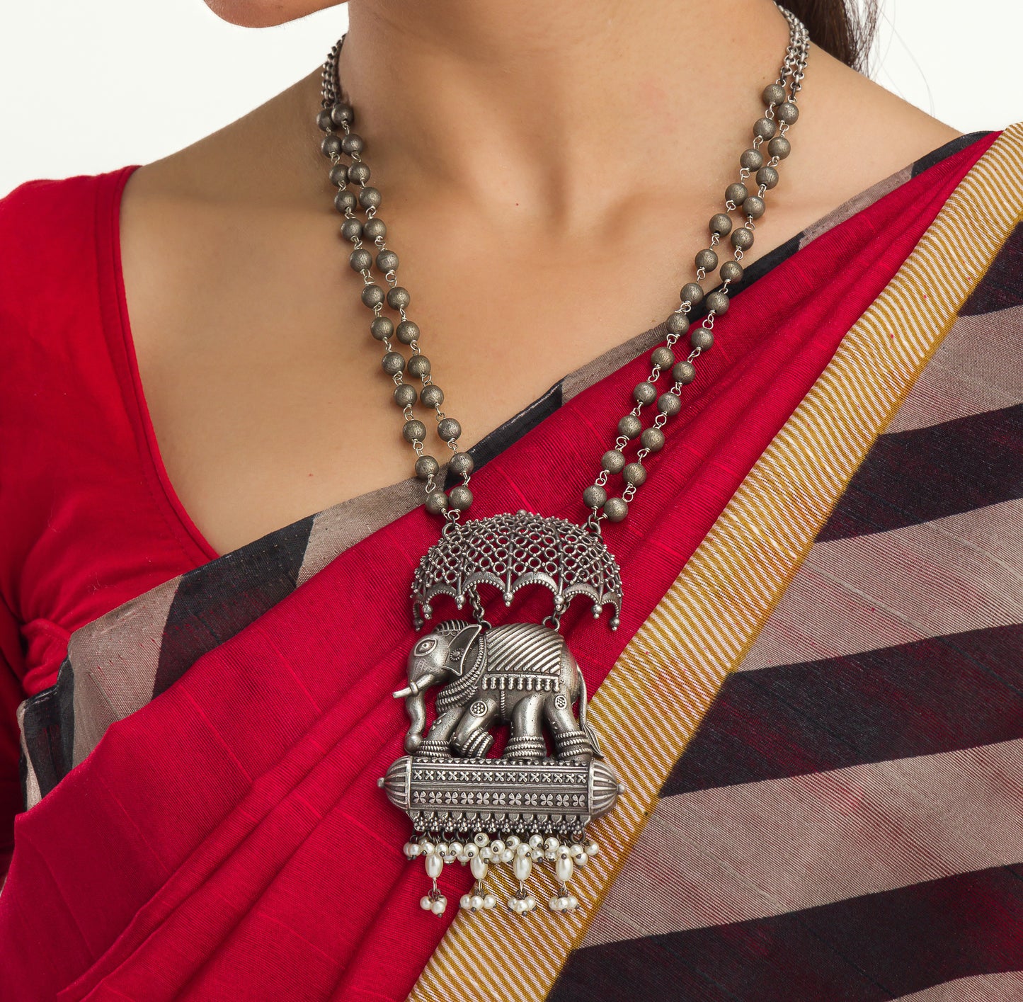 AN OXIDIZED LONG NECKLACE WITH UMBRELLA, ELEPHANT, AND WHITE PEARLS EXUDES VINTAGE CHARM.