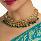 "Stylish gold-tone necklace with green Kundan for vibrant, elegant appeal."
