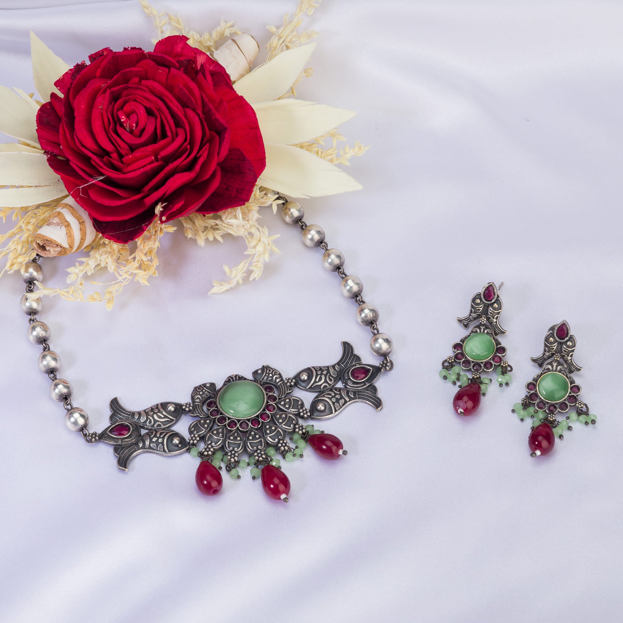 Oxidized choker with light green stones and maroon Kundan blends unique charm.
