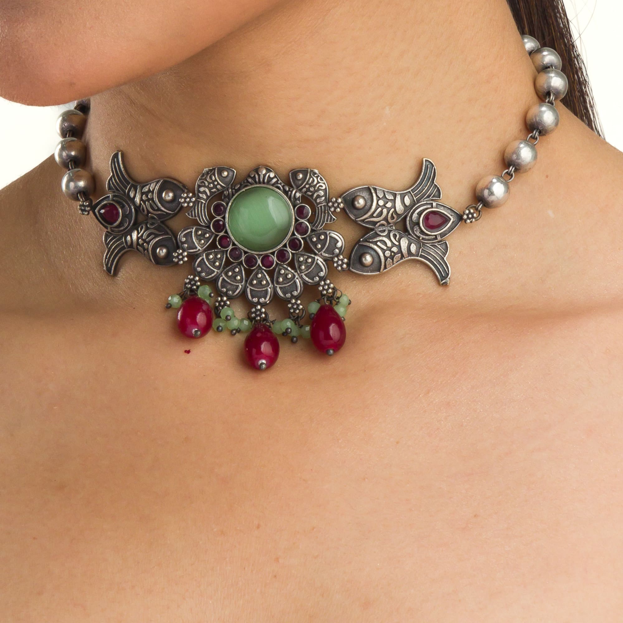 Oxidized choker with light green stones and maroon Kundan blends unique charm.
