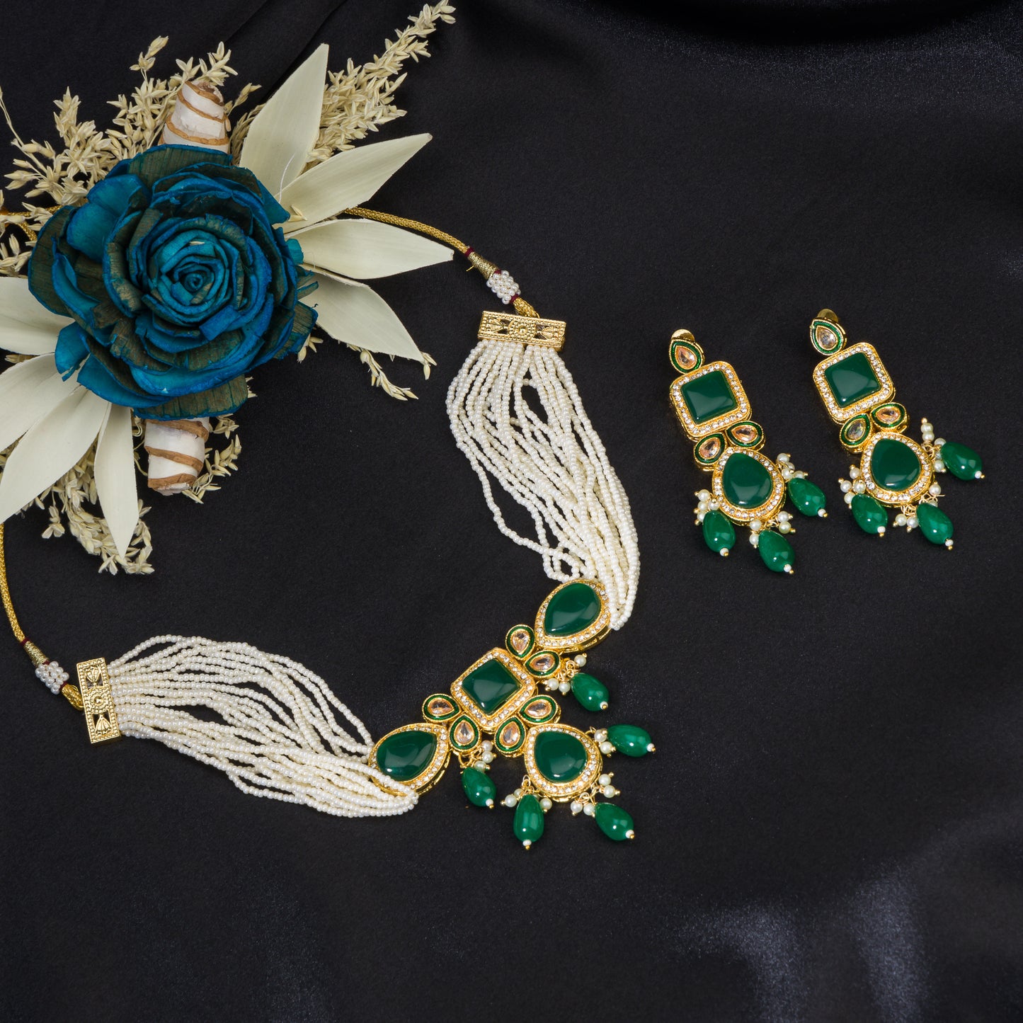 A GREEN KUNDAN AND WHITE PEARL CHOKER OFFERS ELEGANT, VIBRANT FLAIR.