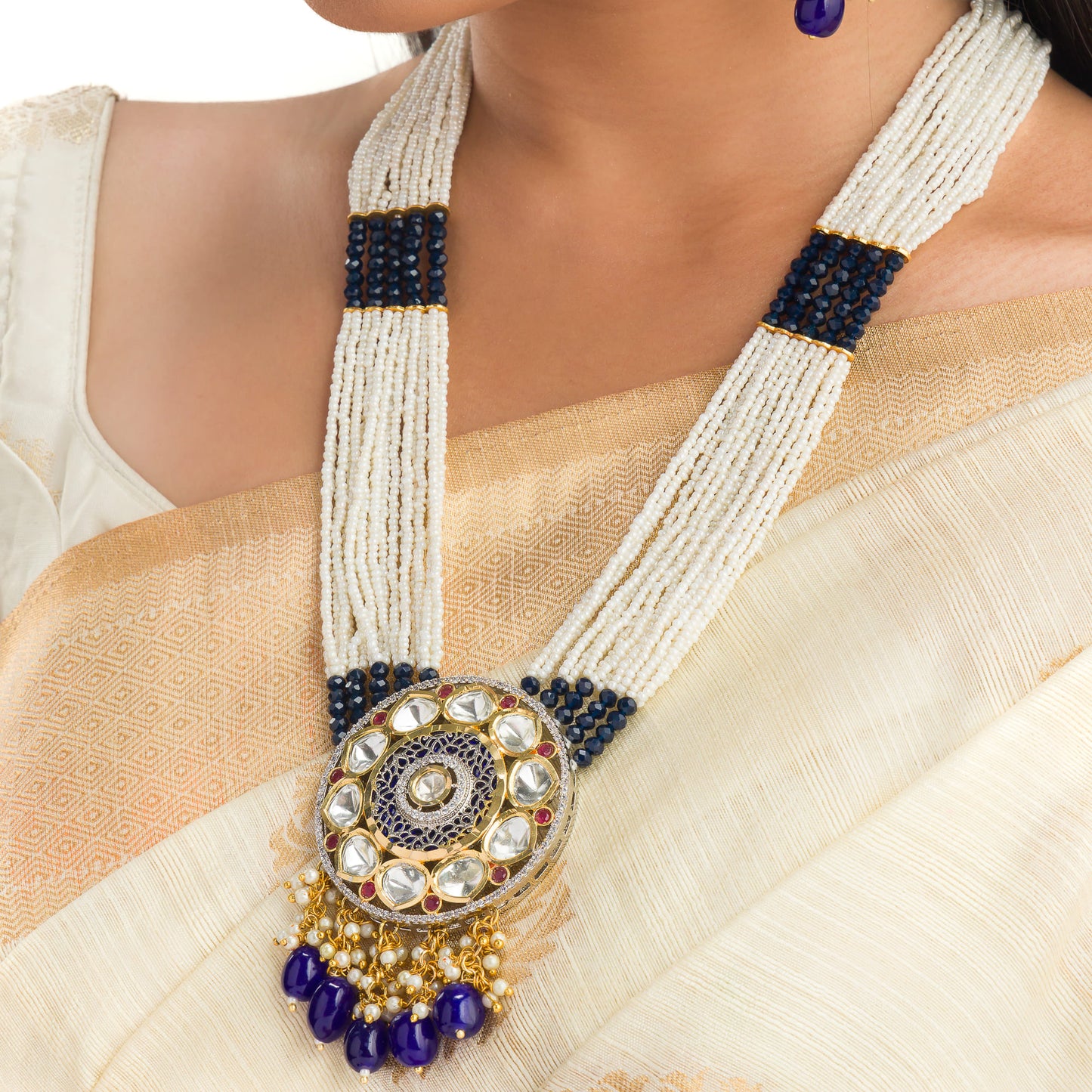 A MAHARANI LONG NECKLACE WITH BLUE KUNDAN AND WHITE PEARLS EXUDES ROYAL SOPHISTICATION.