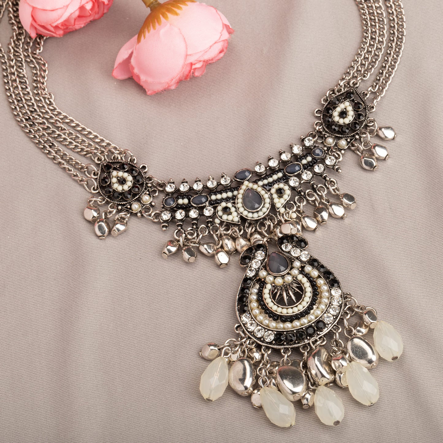 AN OXIDIZED SILVER NECKLACE WITH BLACK AND WHITE BEADS ADDS STYLISH CONTRAST.