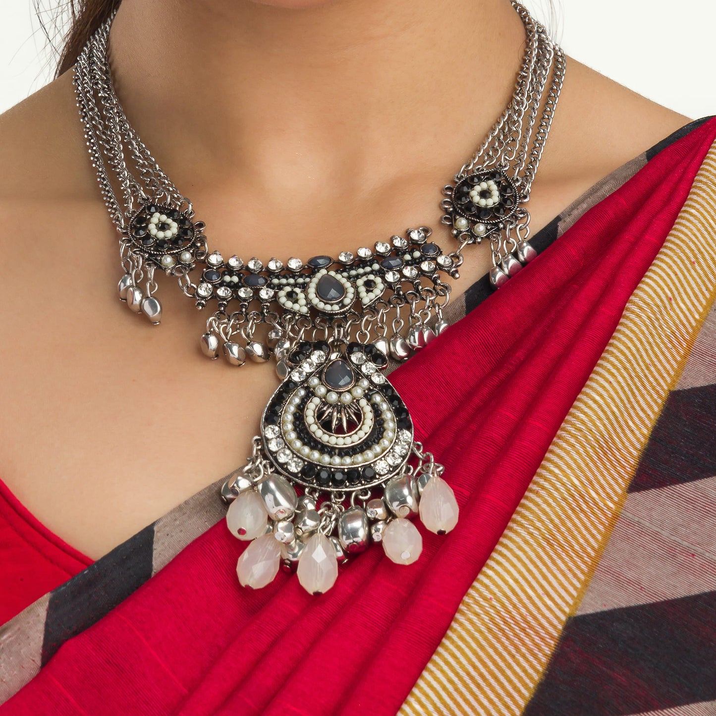 AN OXIDIZED SILVER NECKLACE WITH BLACK AND WHITE BEADS ADDS STYLISH CONTRAST.