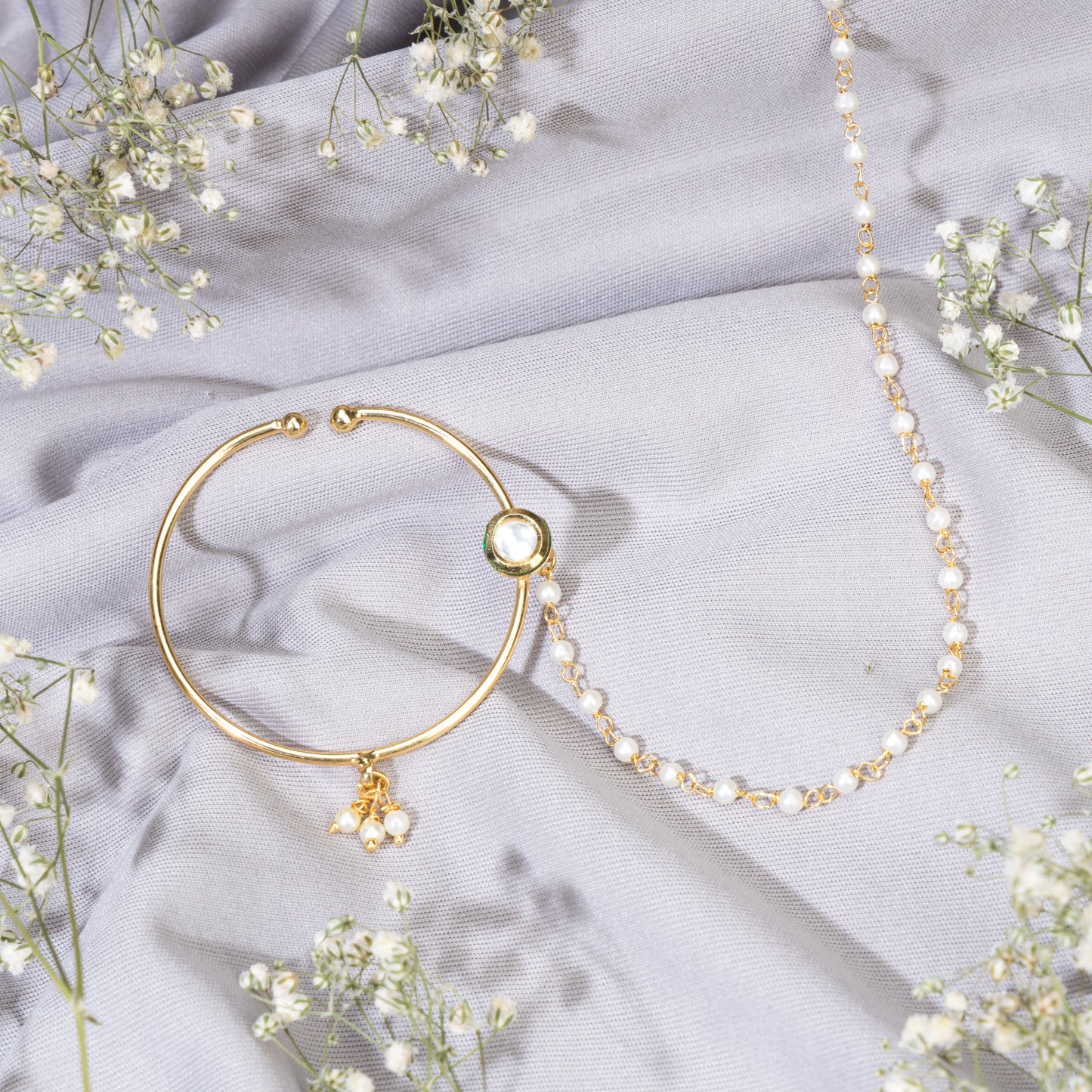 A GOLD-POLISH NATH WITH WHITE PEARLS OFFERS CLASSIC ELEGANCE.