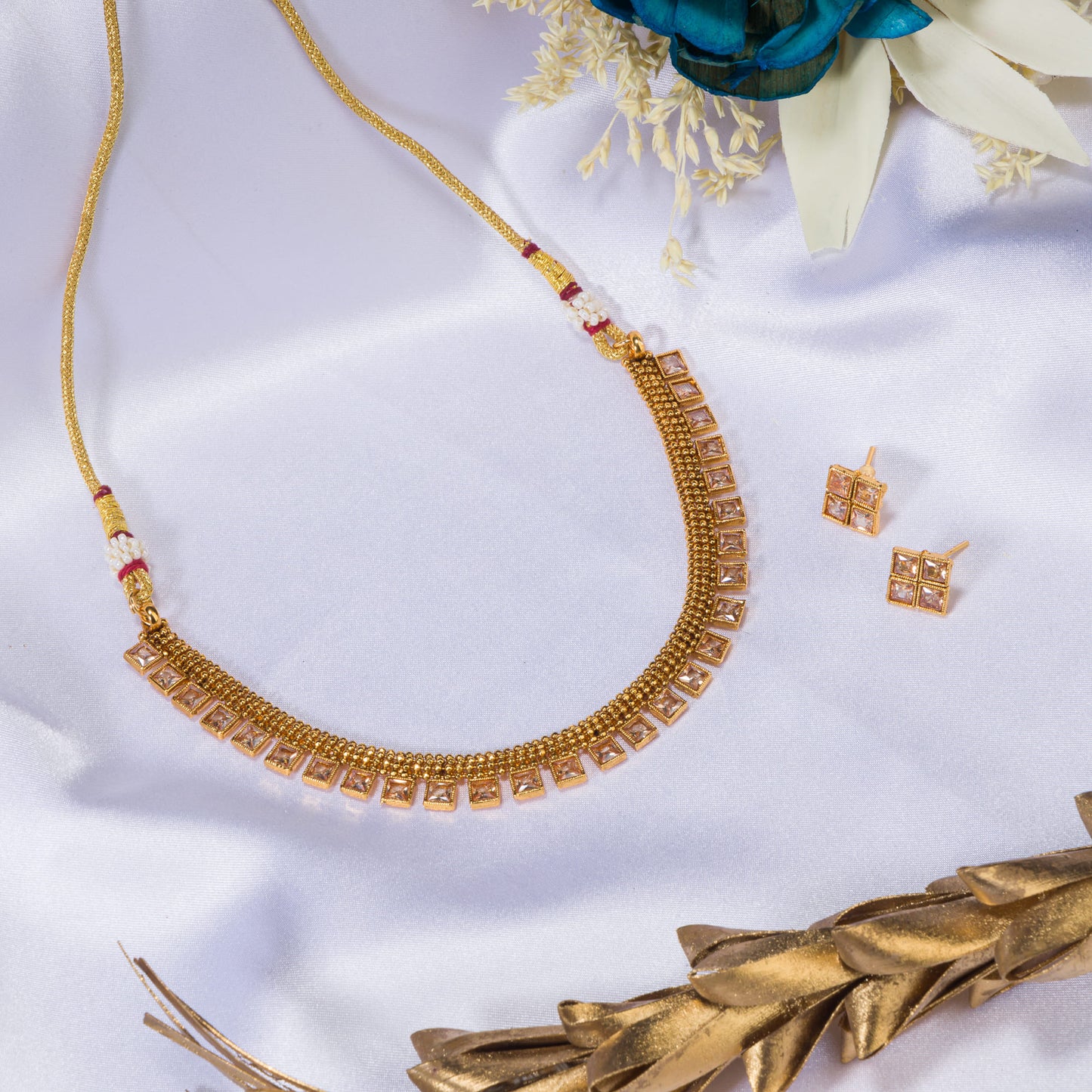 GOLD TONE NECKLACE WITH STONE STUDDED ON IT