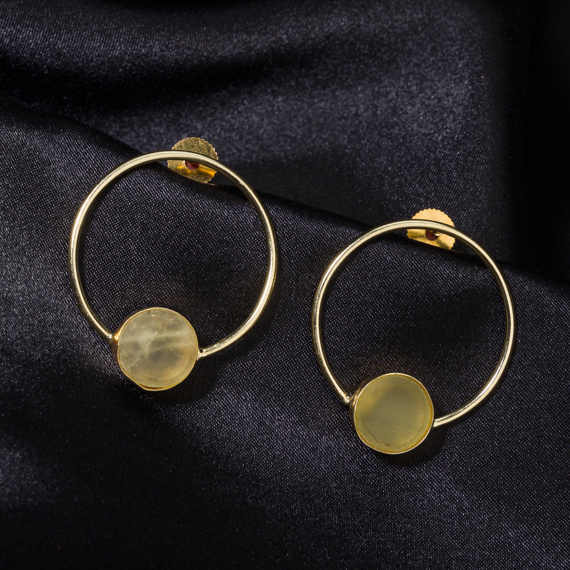 Classic round gold-tone earrings with wheat stones add a warm, sophisticated touch.
