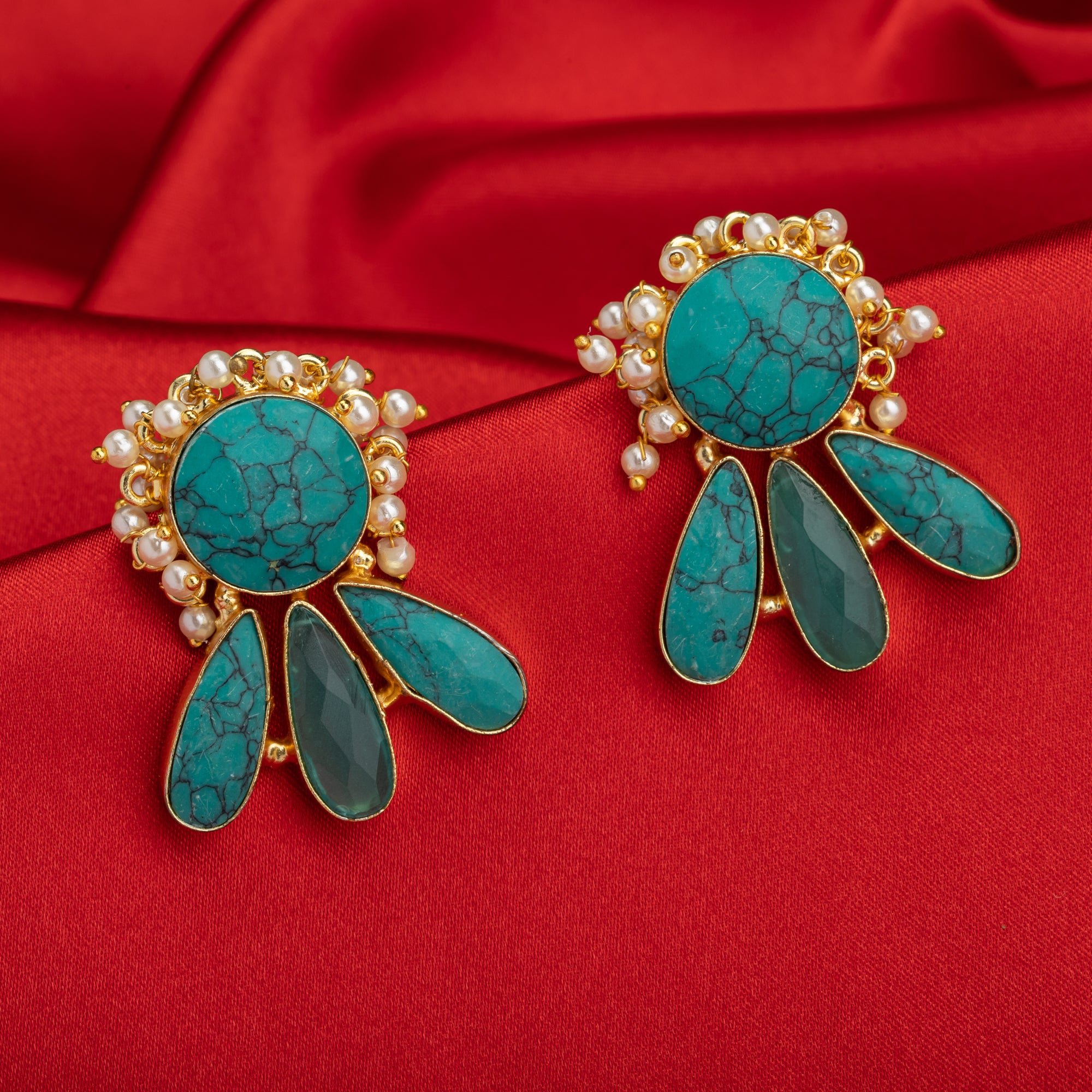 Blue gold-tone earrings with a pearl drop offer classic elegance and vibrant color.
