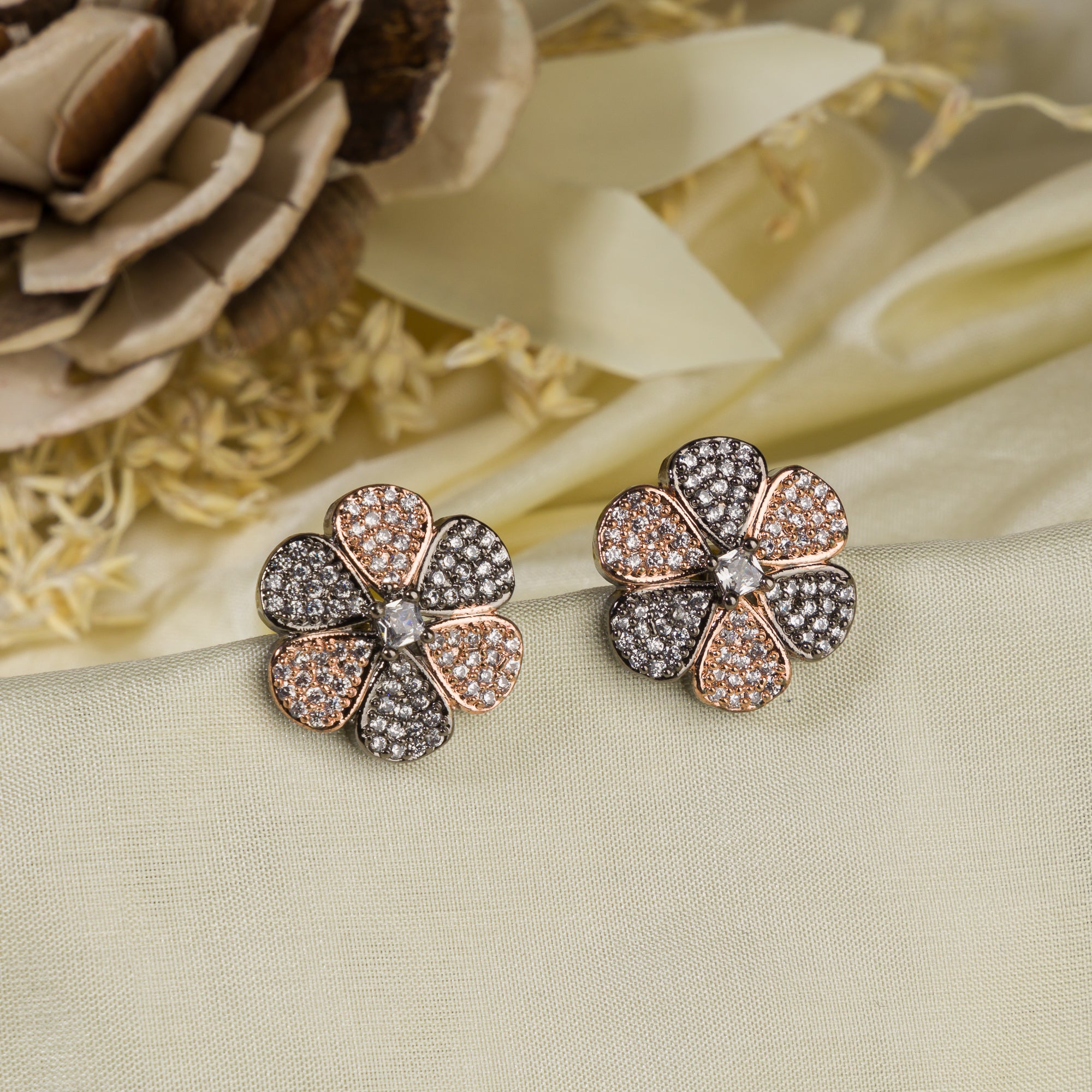 "Zircon flower-shaped earrings with rose gold polish combine warmth and vibrant sparkle."
