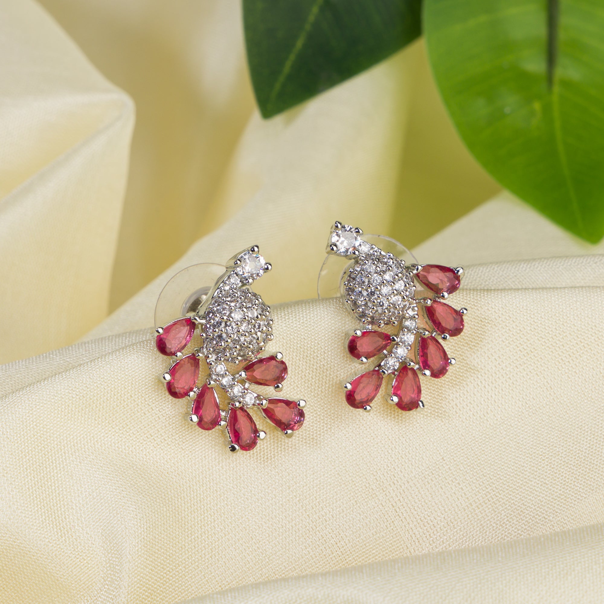 "Peacock-shaped pink zircon studs combine vibrant color with unique, elegant charm."
