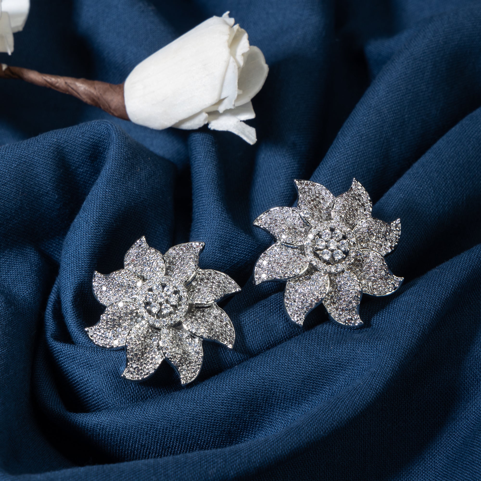 Flowery zircon stud earrings offer charming elegance with sparkling grace for a refined look.
