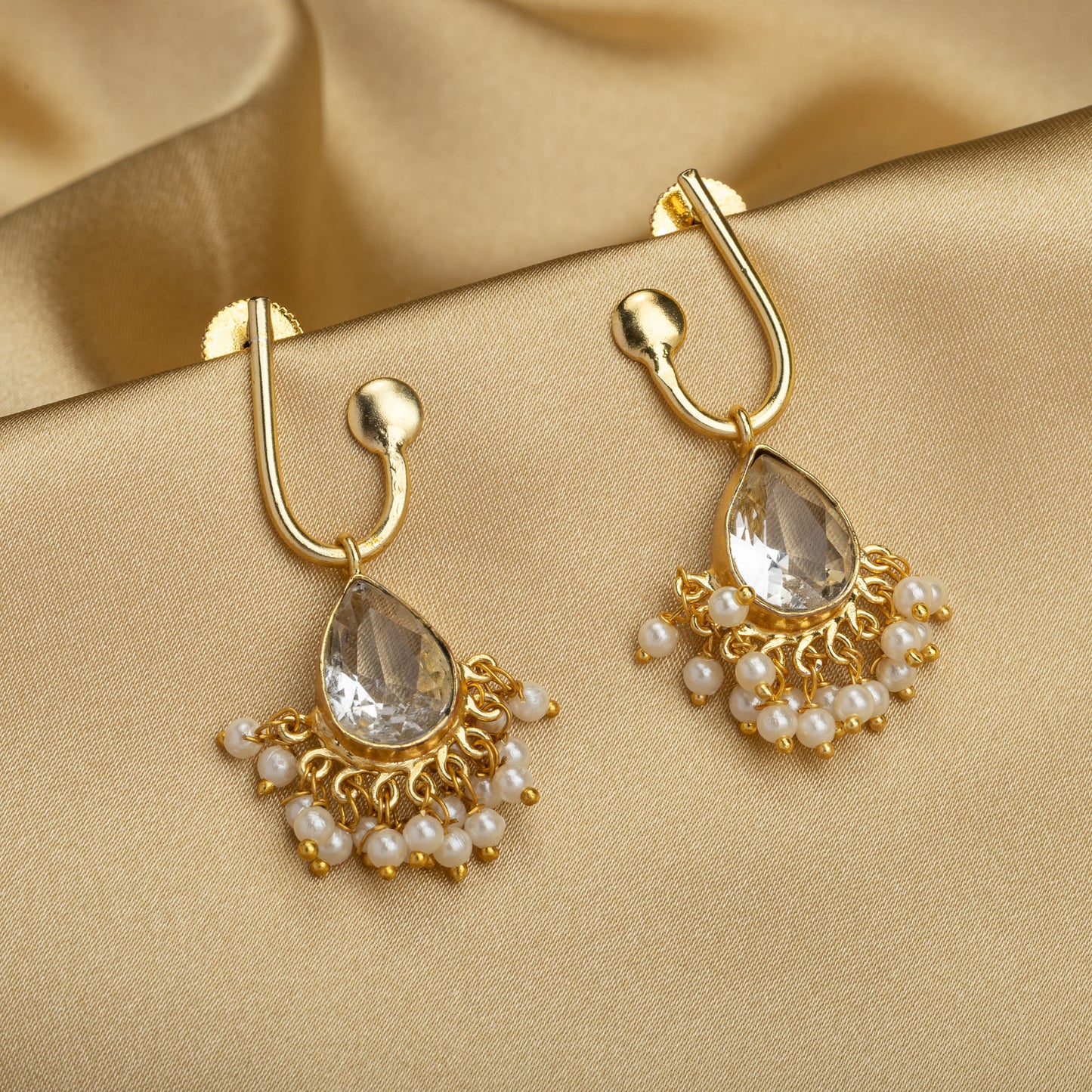 SMALL GOLD-TONE EARRINGS WITH WHITE PEARLS PROVIDE A DELICATE, REFINED TOUCH OF TIMELESS ELEGANCE.