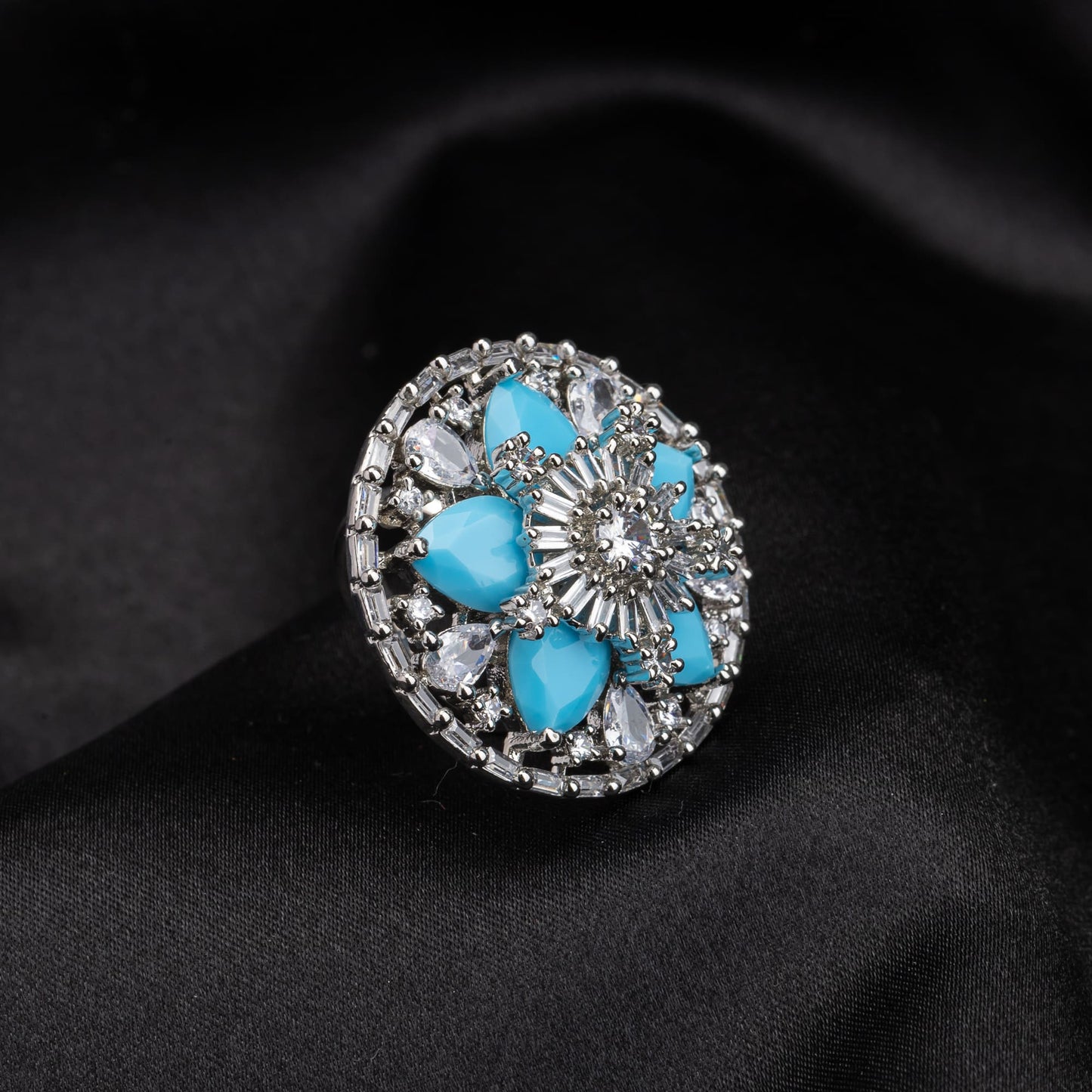 A SMALL AQUA ZIRCON FINGER RING OFFERS A SUBTLE YET ELEGANT TOUCH OF SERENE BLUE BRILLIANCE.