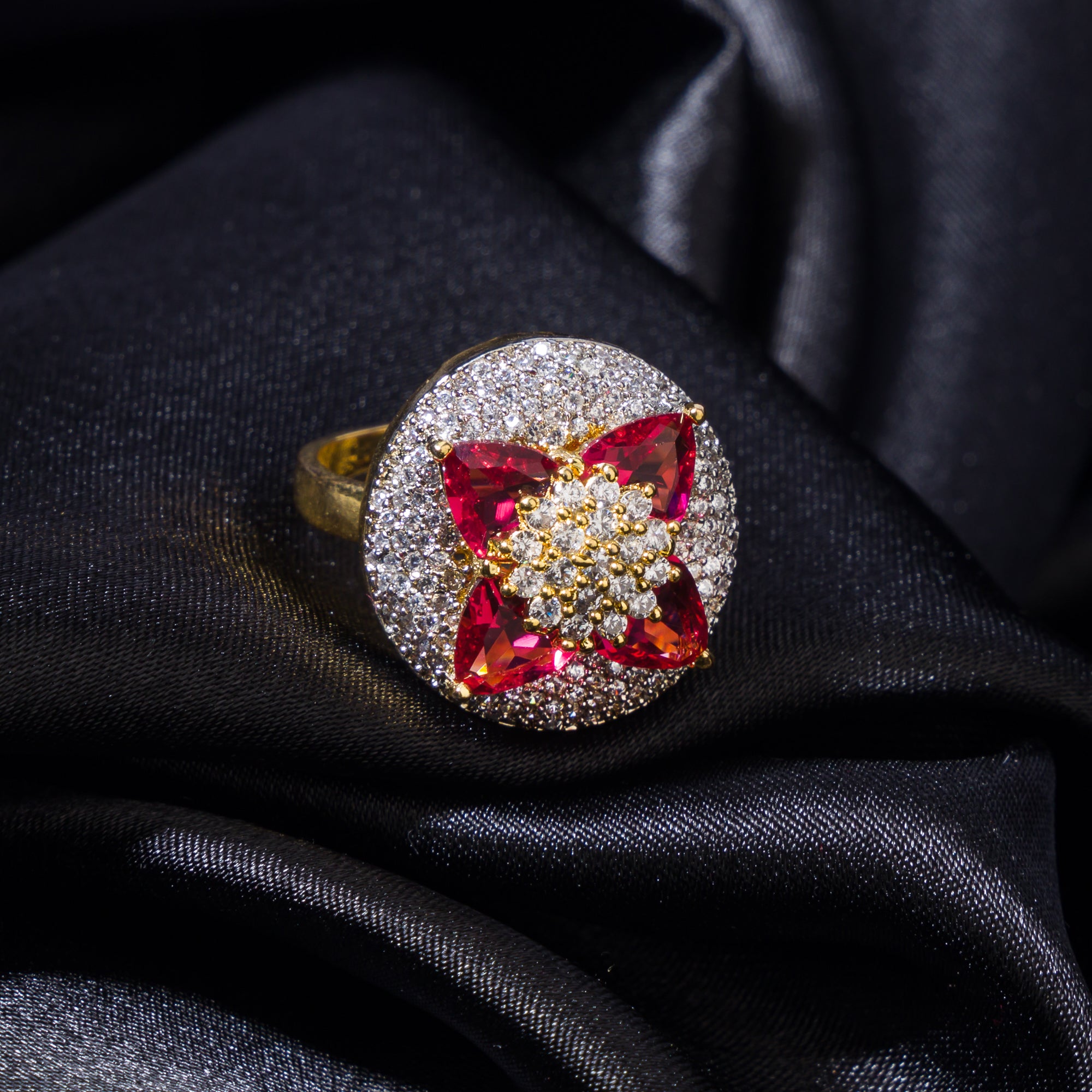 Gold finger ring with red and white zircon stones offers a vibrant floral design and refined elegance.
