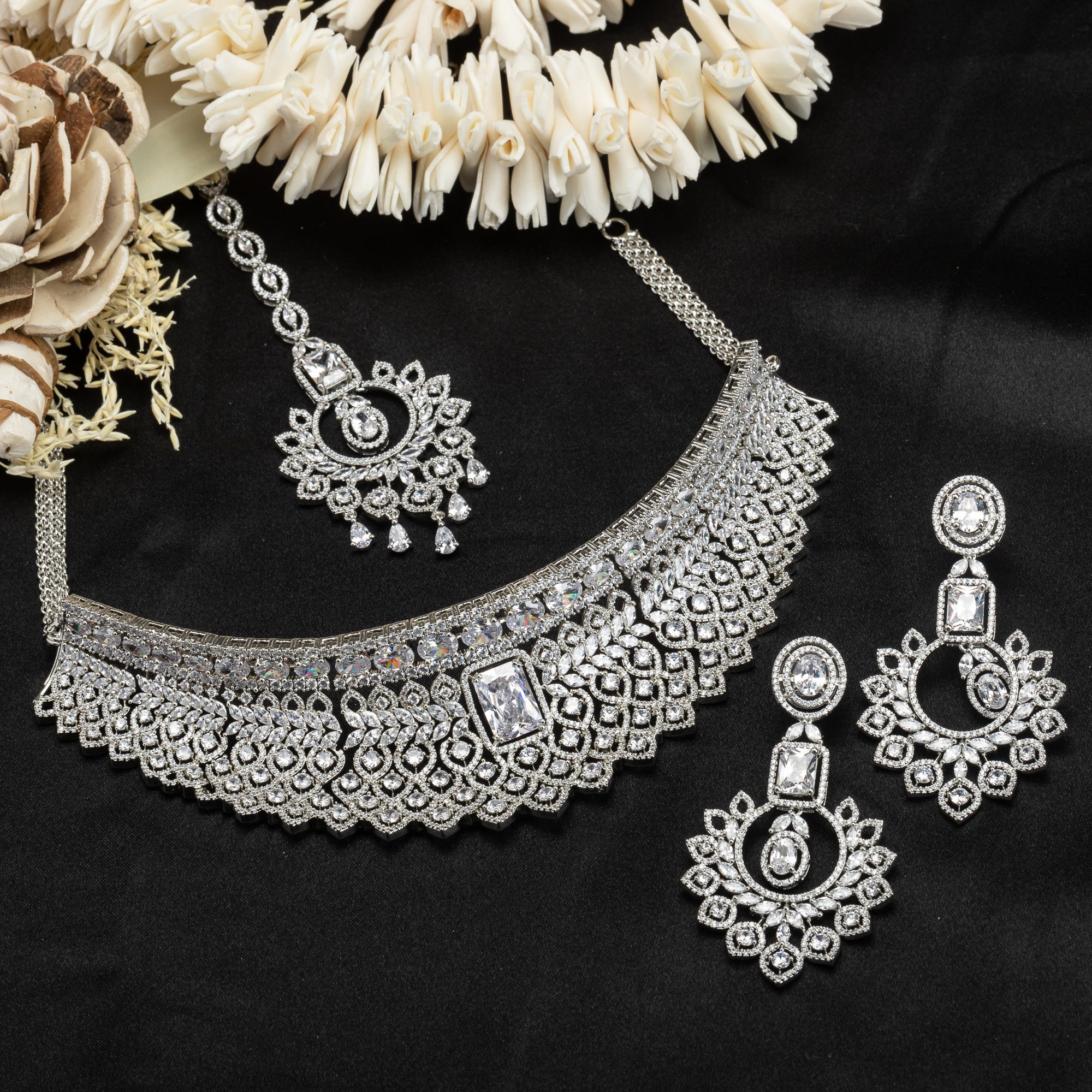 White zircon choker set with matching earrings and maangtika radiates timeless bridal elegance.
