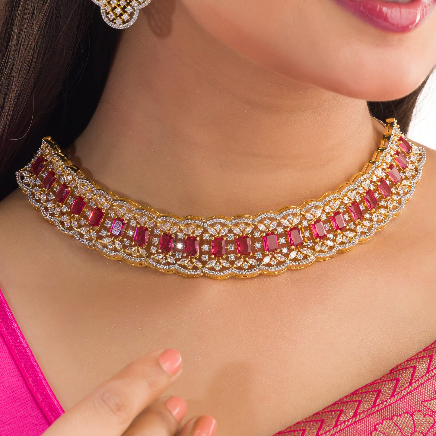 THIS STUNNING RED-COLOURED STONE-STUDDED ZIRCON BRIDAL SET FEATURES A DAZZLING NECKLACE ADORNED WITH INTRICATELY DESIGNED STONES, PERFECT FOR A REGAL BRIDAL LOOK.