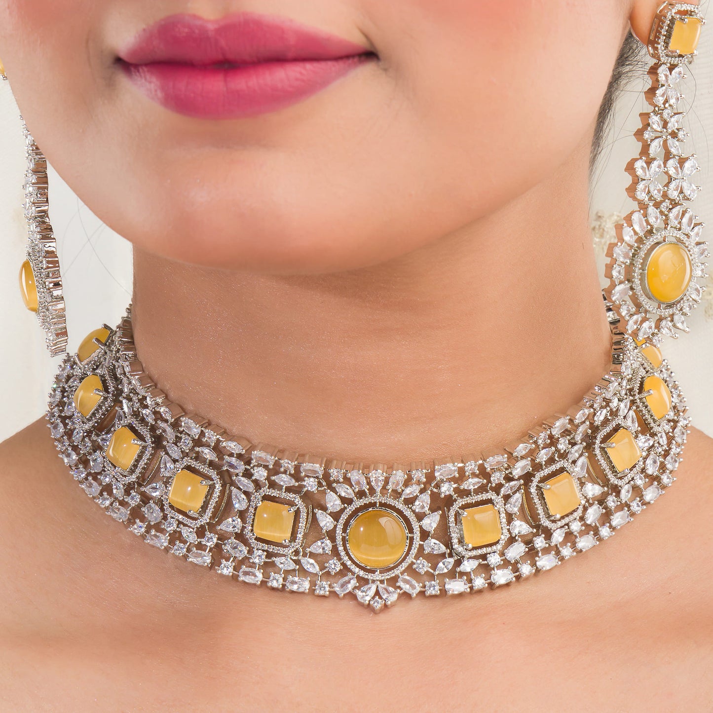 A WHITE ZIRCON-STUDDED NECKLACE SET FEATURES A NECKLACE AND MATCHING EARRINGS