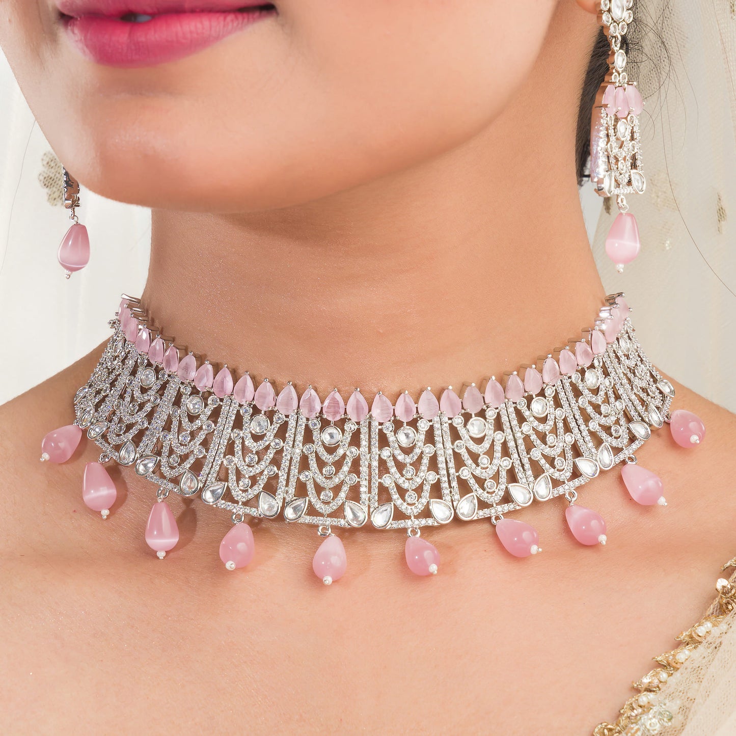 PINK PEARLS AND WHITE ZIRCON-STUDDED BRIDAL SET, INCLUDING CHOKER, EARRINGS, AND MAANGTIKA, FOR AN ELEGANT LOOK.