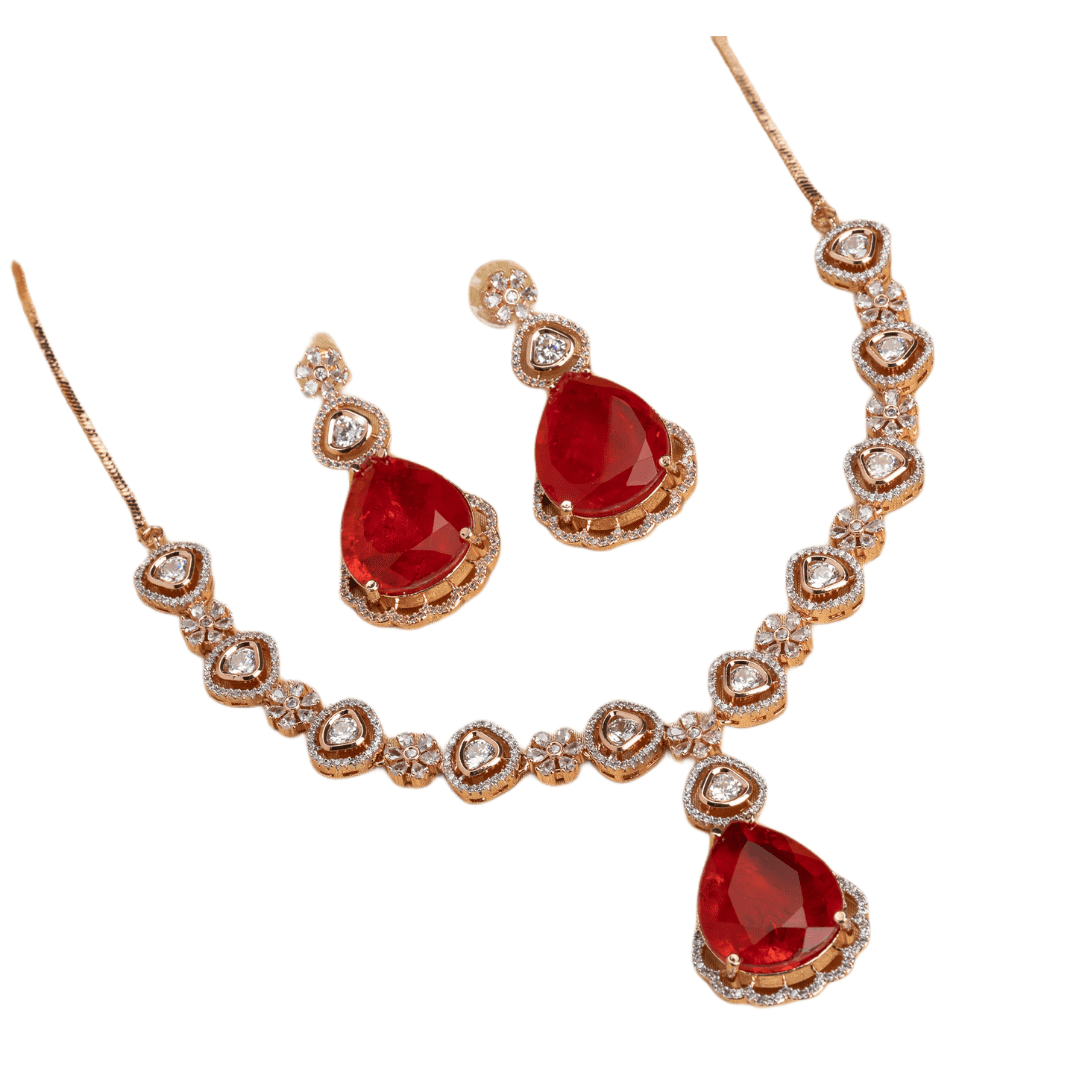 THIS ROSE GOLD POLISHED NECKLACE SET SHOWCASES A STRIKING PENDANT WITH LARGE RED STONES, BEAUTIFULLY ACCENTED BY ZIRCON STUDS.