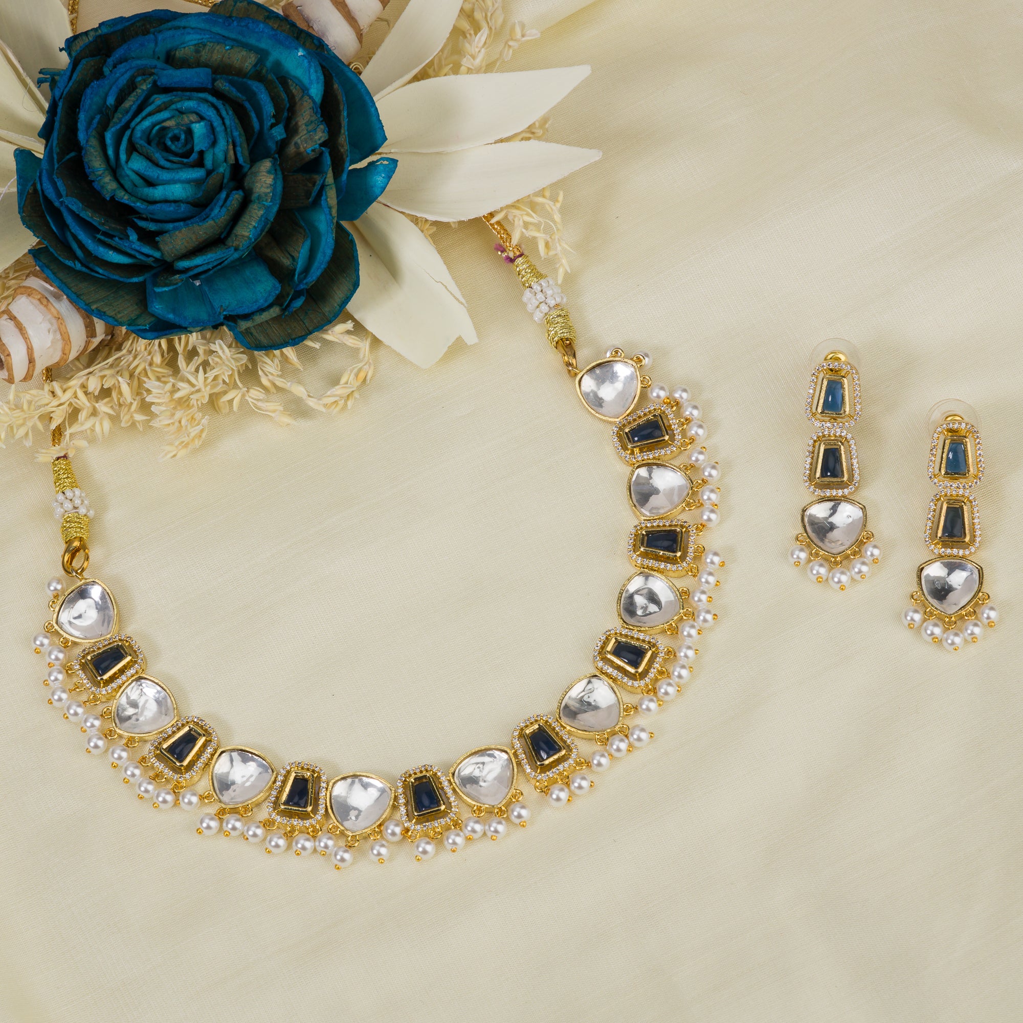 Black polished necklace set with golden, white zircon stones, and pearls for a striking elegant look.
