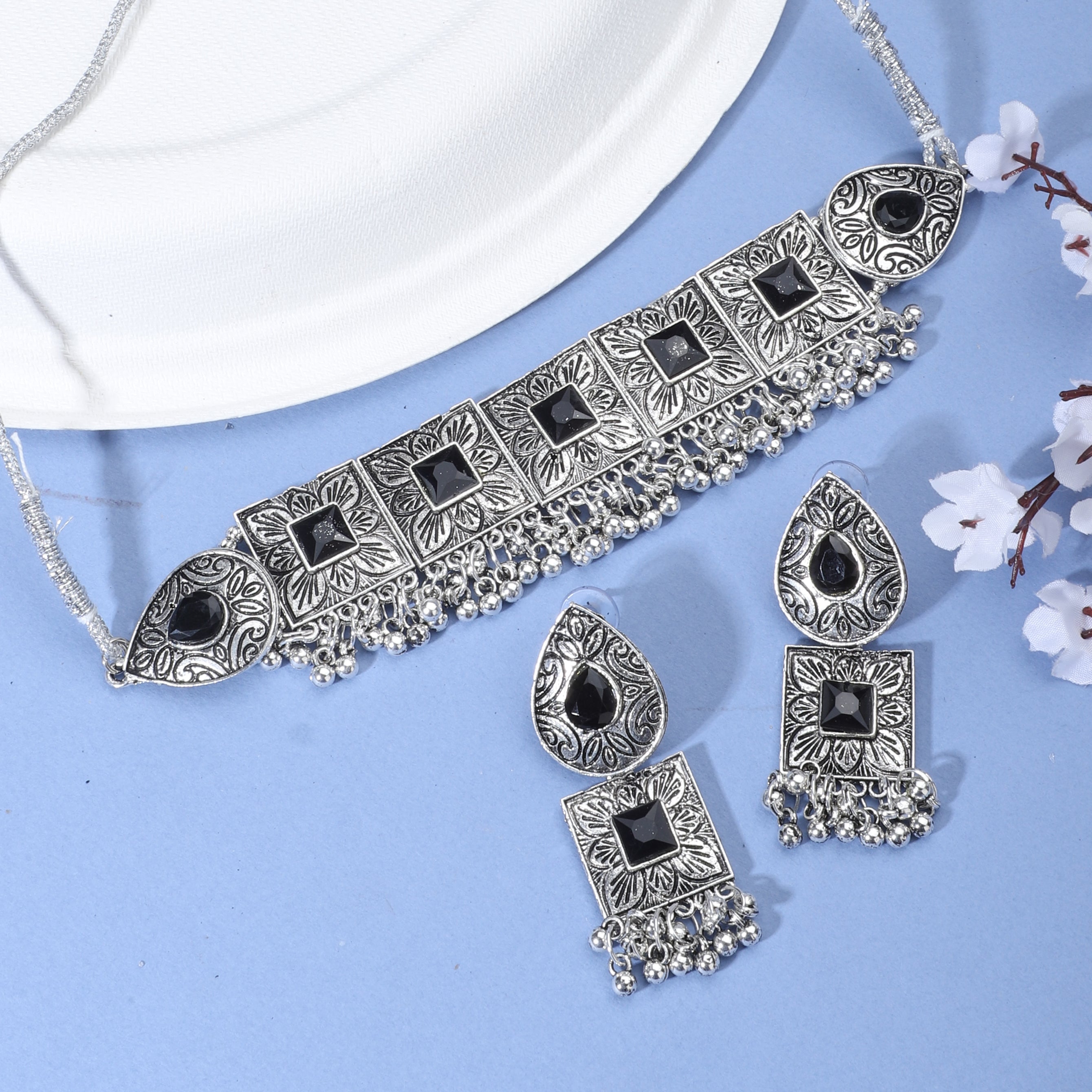 Oxidised choker set with black stones and matching earrings for a stunning festive appearance.
