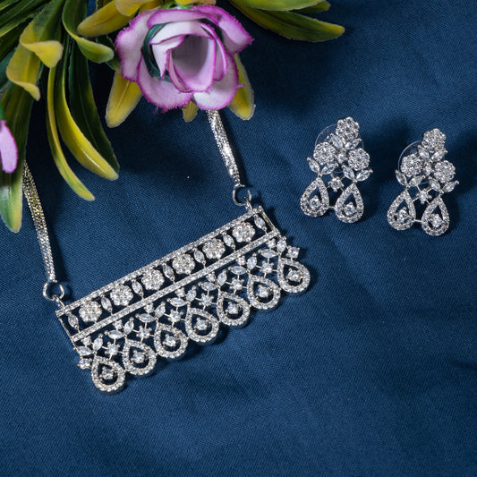 THIS PENDANT SET, ADORNED WITH SPARKLING ZIRCON STONES, COMPLETE WITH MATCHING EARRINGS