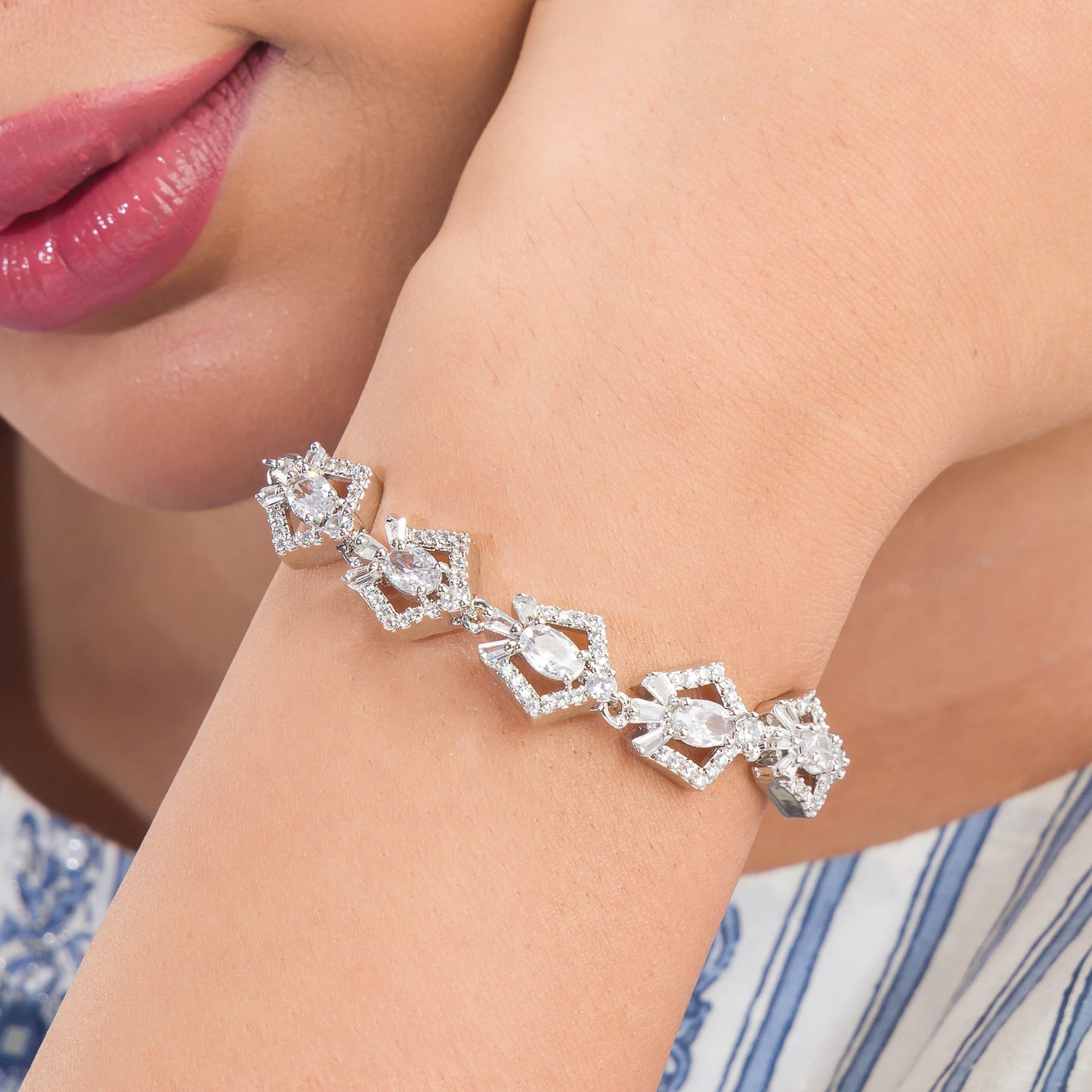 THIS SILVER POLISHED ADJUSTABLE  BRACELET, STUDDED WITH SHIMMERING ZIRCON STONES, IS PERFECT FOR PARTY WEAR.