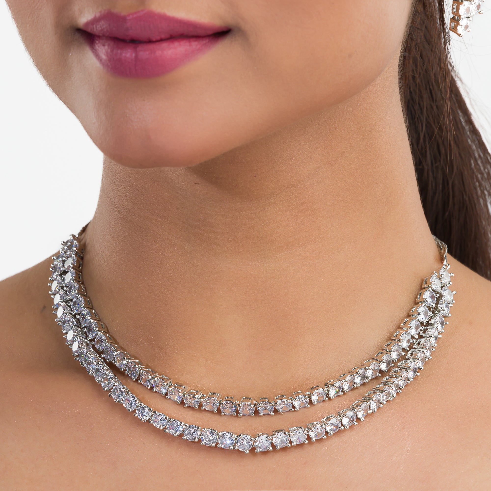 Double-layer silver necklace set with white zircon stones and matching earrings for sophistication.
