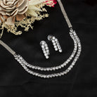 Double-layer silver necklace set with white zircon stones and matching earrings for sophistication.
