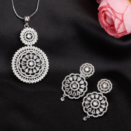 THIS PENDANT SET FEATURES FLORAL DESIGN ADORNED WITH WHITE ZIRCON STONES , PAIRED WITH MATCHING EARRINGS, .