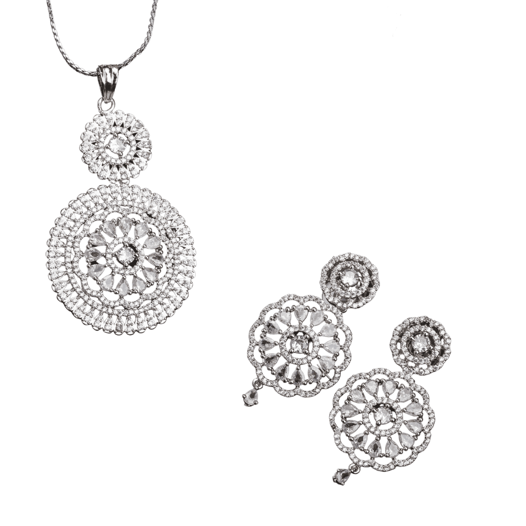 THIS PENDANT SET FEATURES FLORAL DESIGN ADORNED WITH WHITE ZIRCON STONES , PAIRED WITH MATCHING EARRINGS, .