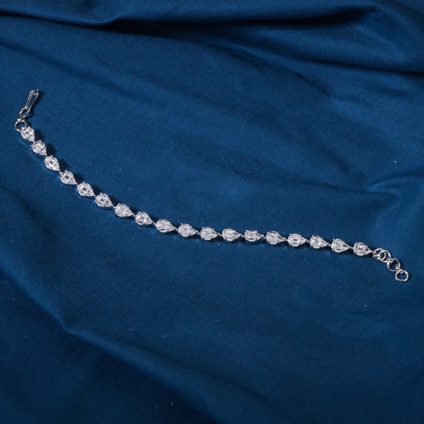 THIS SILVER-POLISHED CHAIN BRACELET, STUDDED WITH SHIMMERING ZIRCON STONES, IS PERFECT FOR PARTY WEAR.