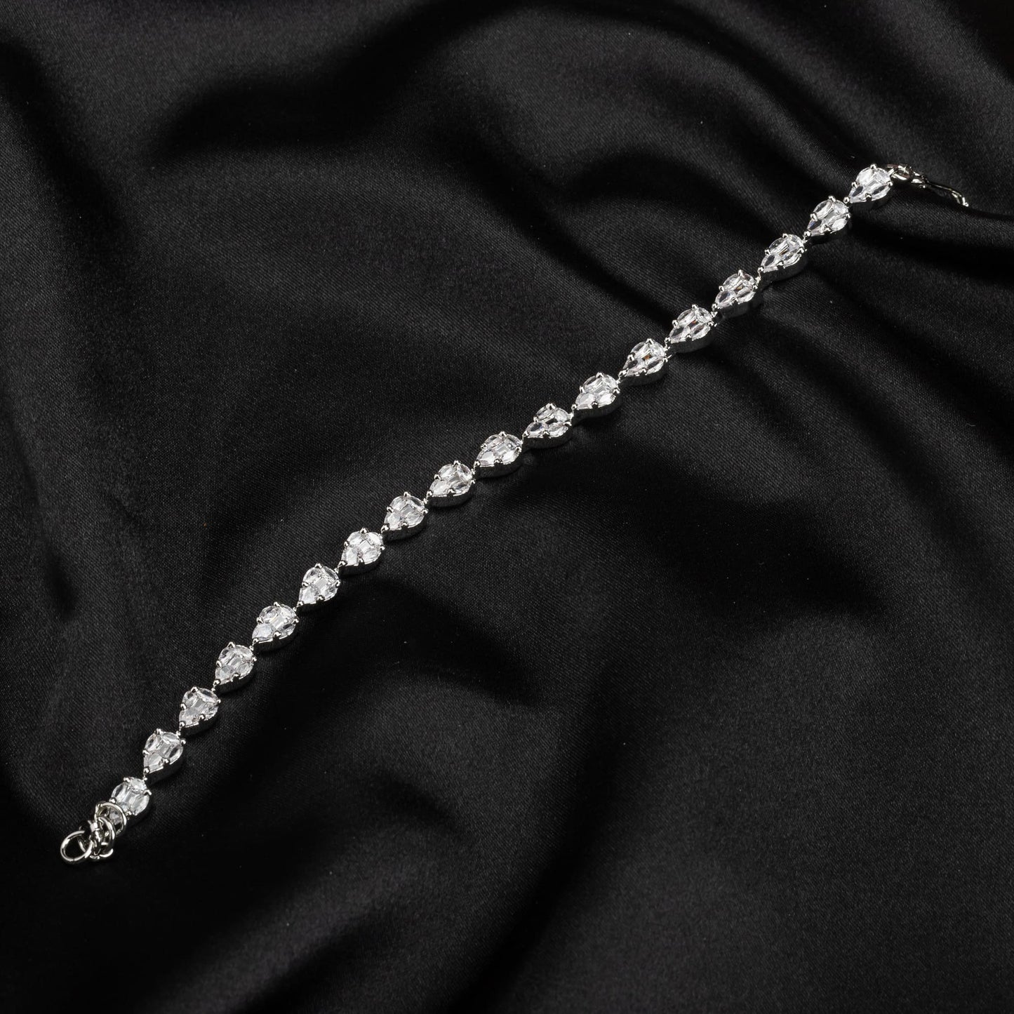 THIS SILVER-POLISHED CHAIN BRACELET, STUDDED WITH SHIMMERING ZIRCON STONES, IS PERFECT FOR PARTY WEAR.