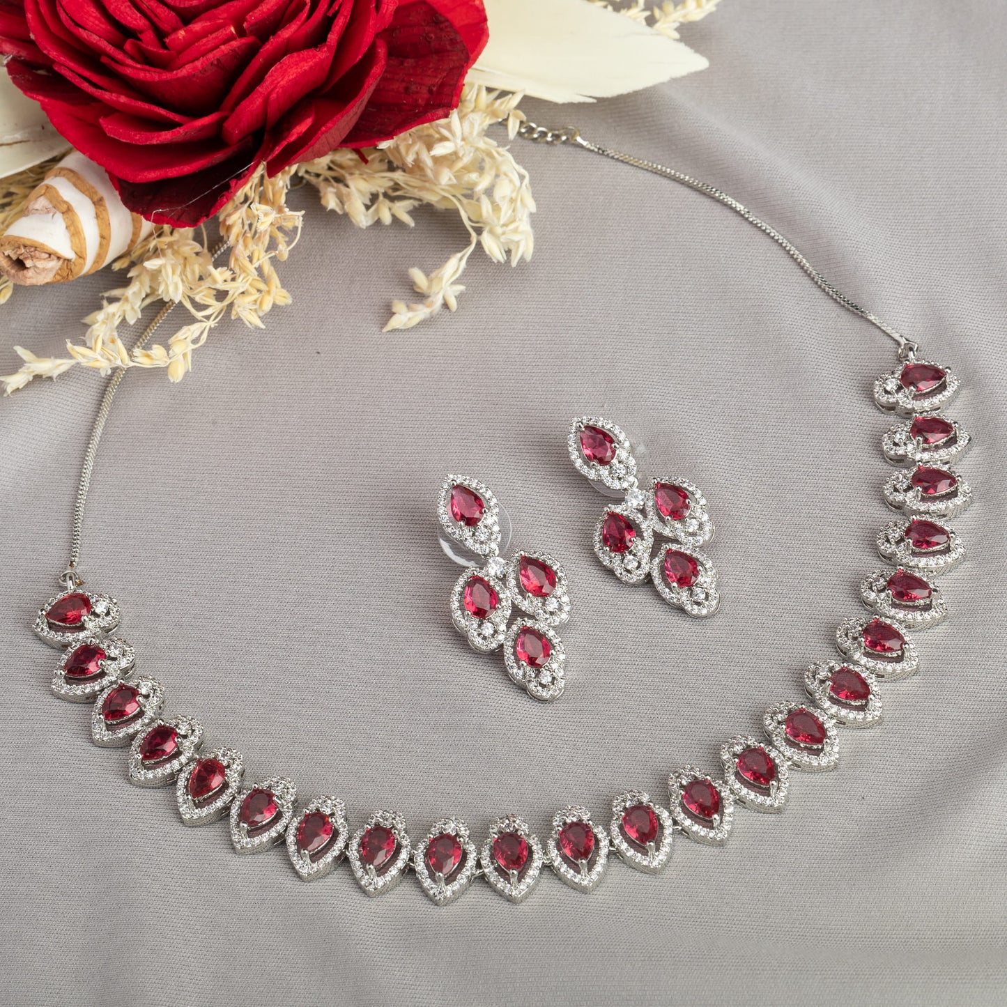 MAKE A BOLD STATEMENT WITH THIS RED STONE-STUDDED ZIRCON NECKLACE SET. ITS VIBRANT STONES AND SPARKLING ZIRCONS CREATE A STRIKING AND ELEGANT LOOK.