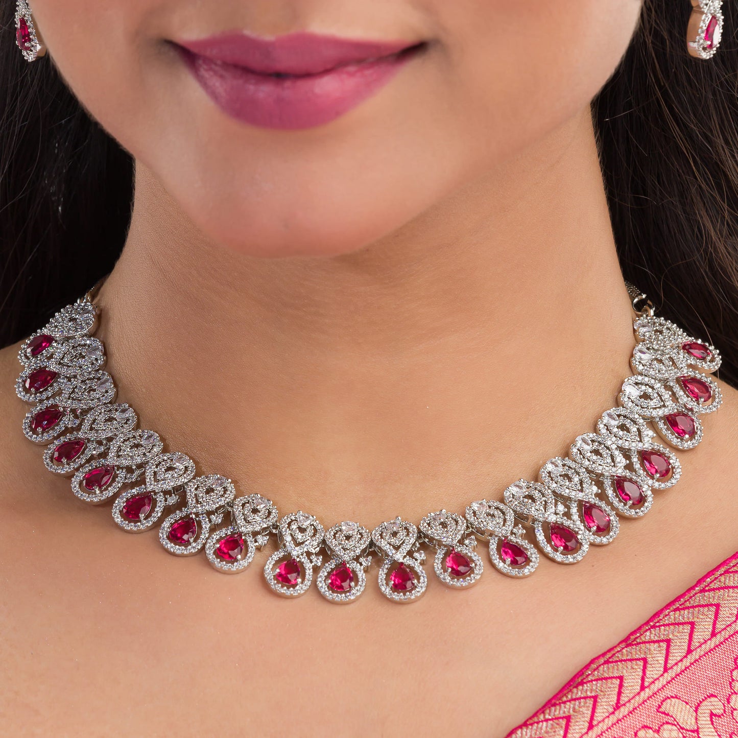 MAKE A BOLD STATEMENT WITH THIS RED STONE-STUDDED ZIRCON NECKLACE SET. ITS VIBRANT STONES AND SPARKLING ZIRCONS CREATE A STRIKING AND ELEGANT LOOK.