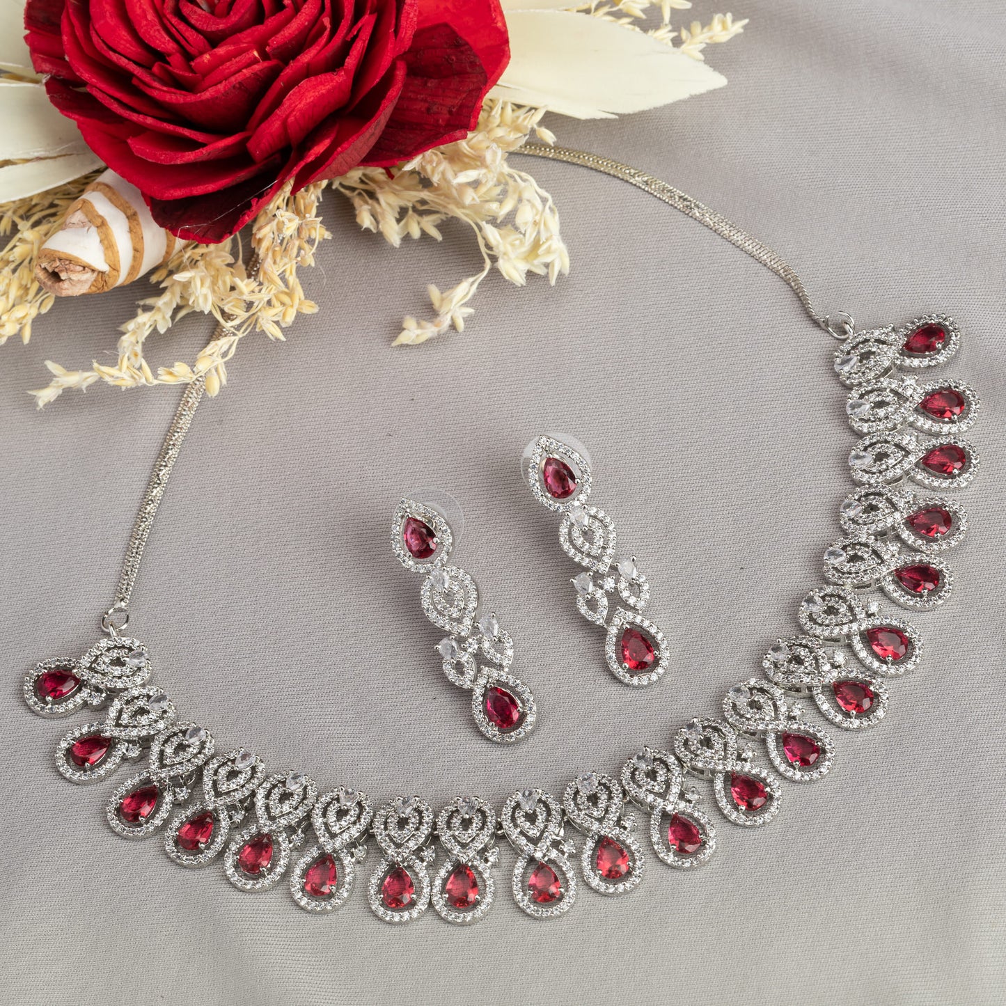 MAKE A BOLD STATEMENT WITH THIS RED STONE-STUDDED ZIRCON NECKLACE SET. ITS VIBRANT STONES AND SPARKLING ZIRCONS CREATE A STRIKING AND ELEGANT LOOK.