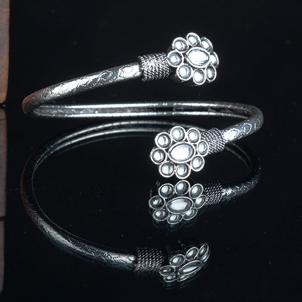 An elegant oxidised silver bracelet adorned with white stones is perfect for a timeless party look.
