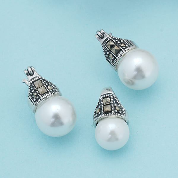 ADORN YOURSELF WITH ELEGANCE WITH THIS PEARL-STUDDED 925 SILVER PENDANT AND EARRINGS SET.