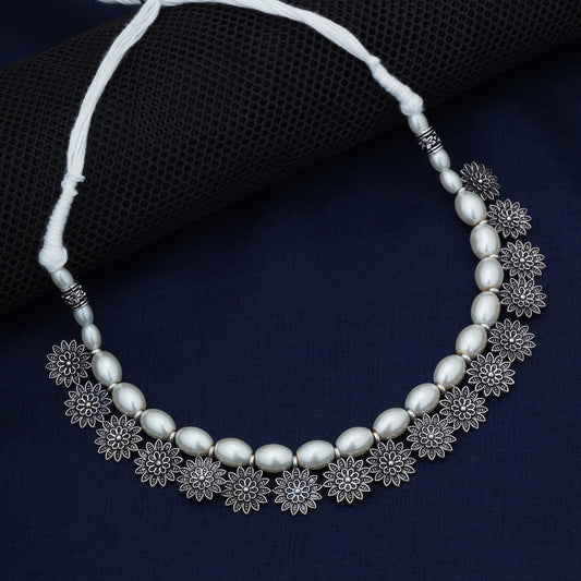 STYLISH OXIDIZED CHOKER WITH INTRICATE FLORAL DESIGN, ADORNED WITH WHITE PEARLS. THIS ELEGANT PIECE COMBINES VINTAGE CHARM