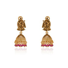  Radha Krishna temple necklace set with red pearls, showcasing intricate gold-tone craftsmanship.
