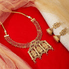  Radha Krishna temple necklace set with red pearls, showcasing intricate gold-tone craftsmanship.
