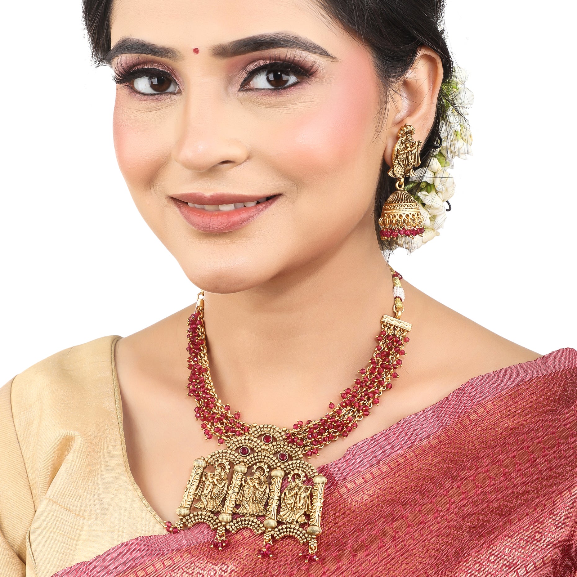  Radha Krishna temple necklace set with red pearls, showcasing intricate gold-tone craftsmanship.
