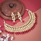 Kundan necklace set with red pearls, featuring two layers of intricate Kundan work and matching earrings.
