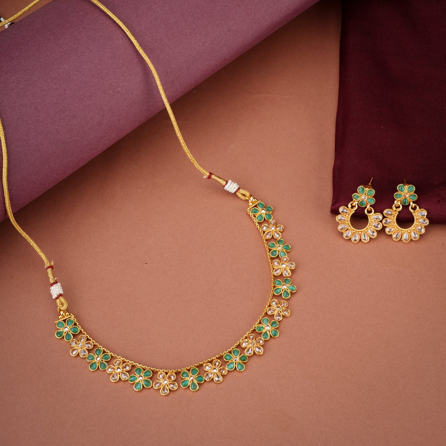 GREEN AND GOLDEN KUNDAN-STUDDED NECKLACE SET SHOWCASES A BEAUTIFUL  KUNDAN WORK.