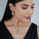 Elegant 925 silver pendant set with lustrous pearls and matching earrings for a sophisticated look.
