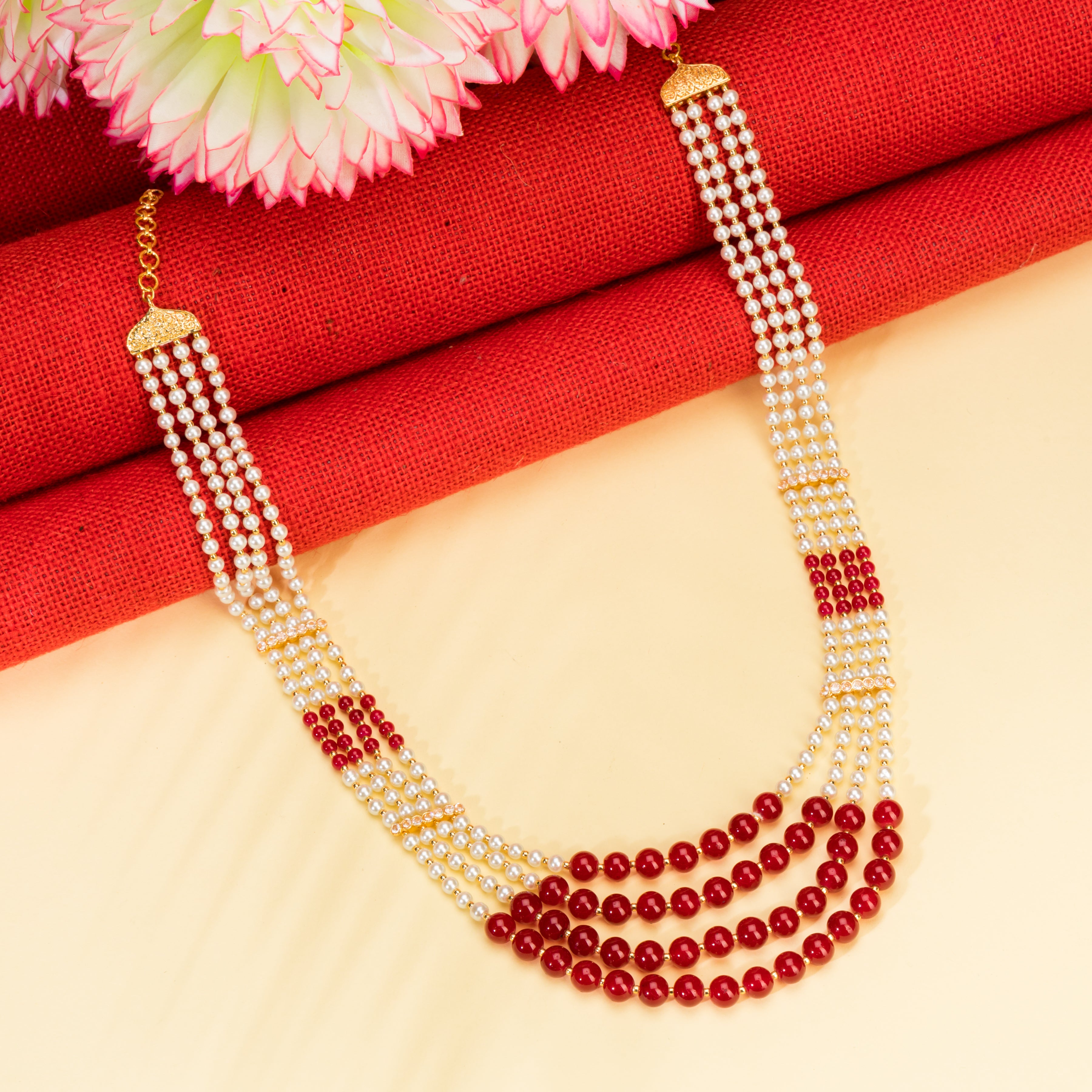 Stunning long necklace set with white and red pearls, adding elegance and vibrancy.
