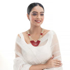 Stunning long necklace set with white and red pearls, adding elegance and vibrancy.
