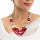 Stunning long necklace set with white and red pearls, adding elegance and vibrancy.
