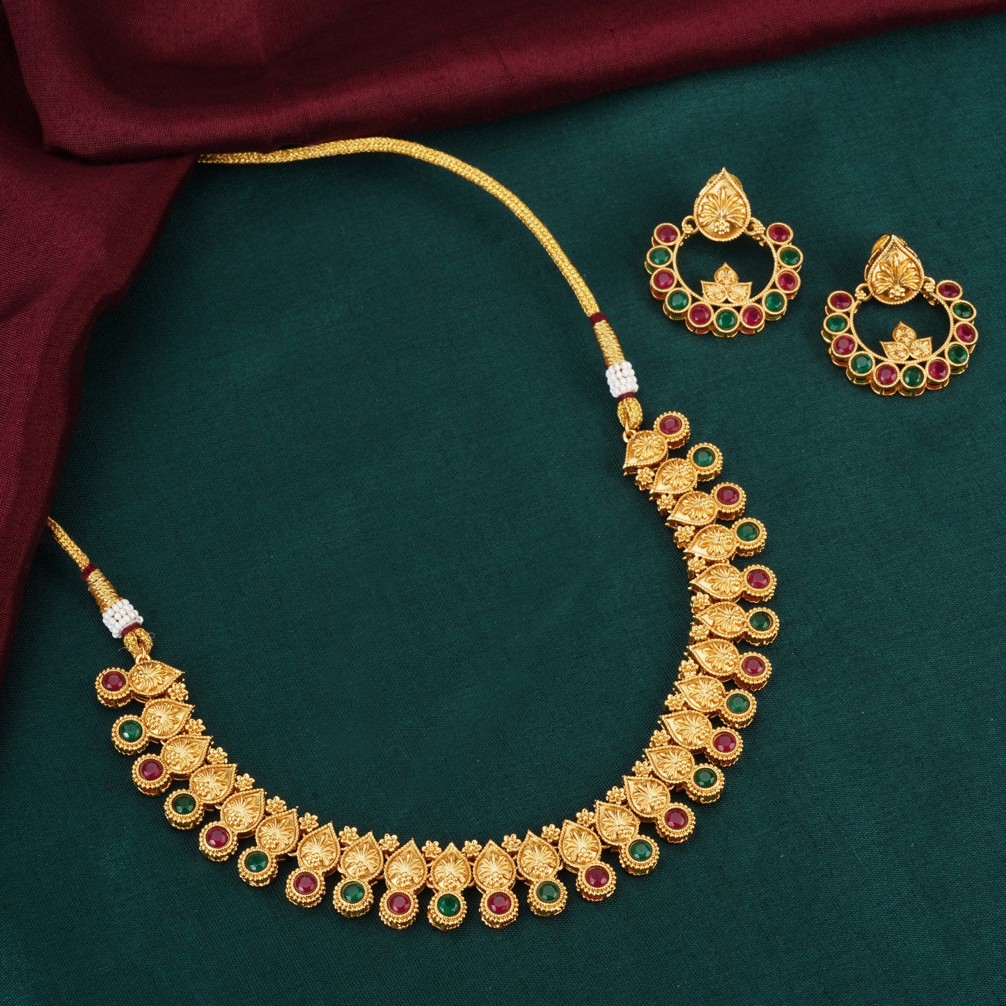 A GOLDTONE NECKLACE SET INCLUDES A NECKLACE AND MATCHING EARRINGS WITH A GOLD-COLORED FINISH,